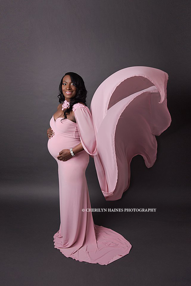 studio maternity portraits in Baton Rouge, Louisiana; pregnant mom wearing light pink maternity gown with long flowing train