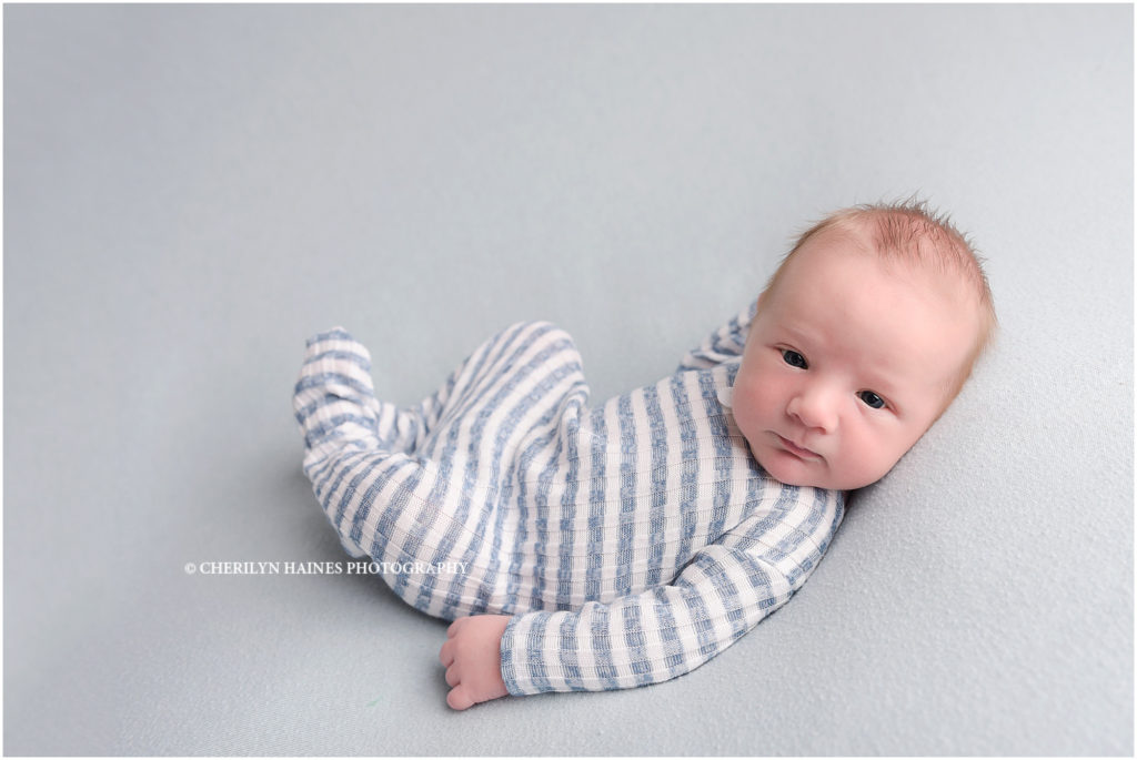 8 day old newborn baby boy photographed by cherilyn haines photography wearing blue and white striped footed pajamas