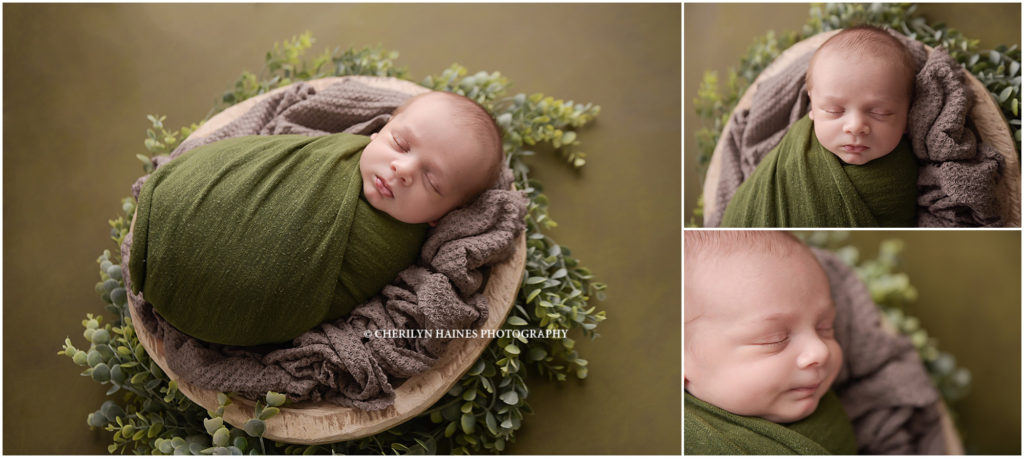 3 week old newborn baby boy photographed swaddled in green laying on greenery