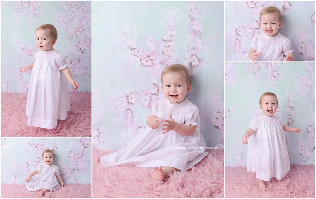 1 year old baby girl photographed on aqua and pink floral backdrop 
