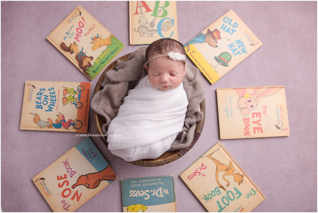 newborn baby girl photographed with vintage dr. seuss books