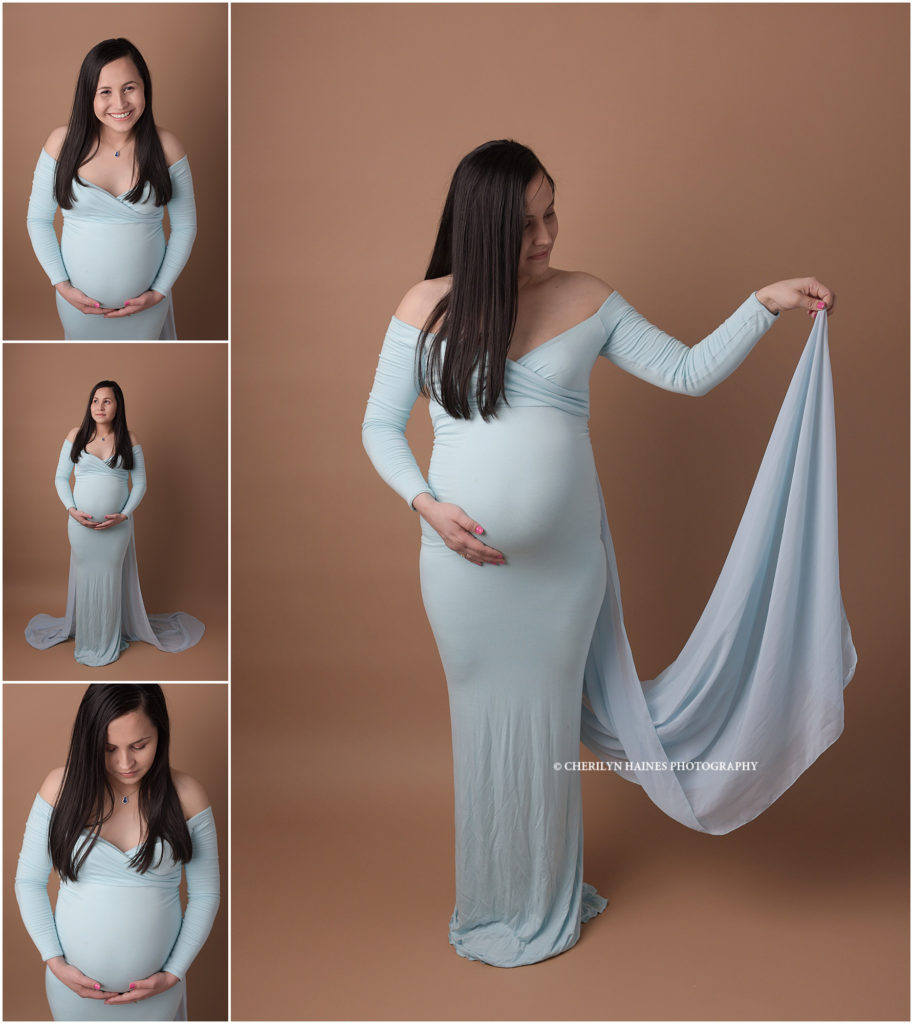 maternity portrait session on dark tan backdrop with mama wearing a light blue maternity gown