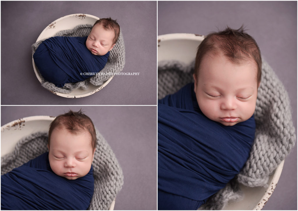 newborn session in baton rouge, louisiana; baby boy swaddled in navy laying on gray backdrop