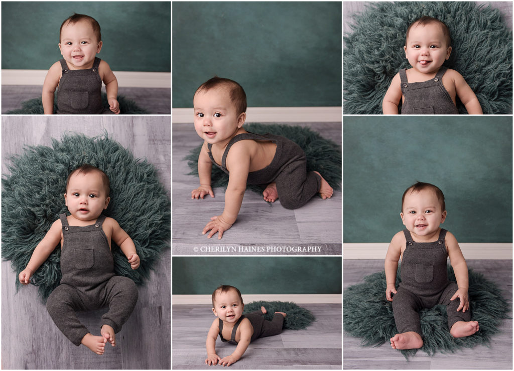 baby photographers in baton rouge; 6 month old baby boy wearing gray knit overalls on a dark teal rug