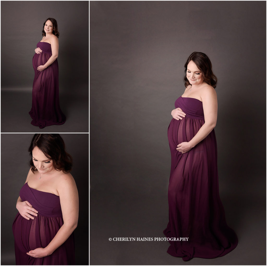 maternity portraits in baton rouge; pregnant mom wearing flow dark plum colored gown on gray backdrop