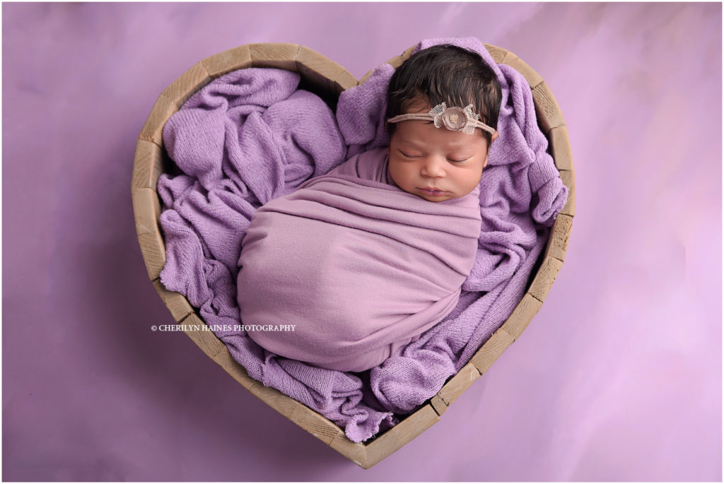 9 day old newborn photographed in wooden heart prop