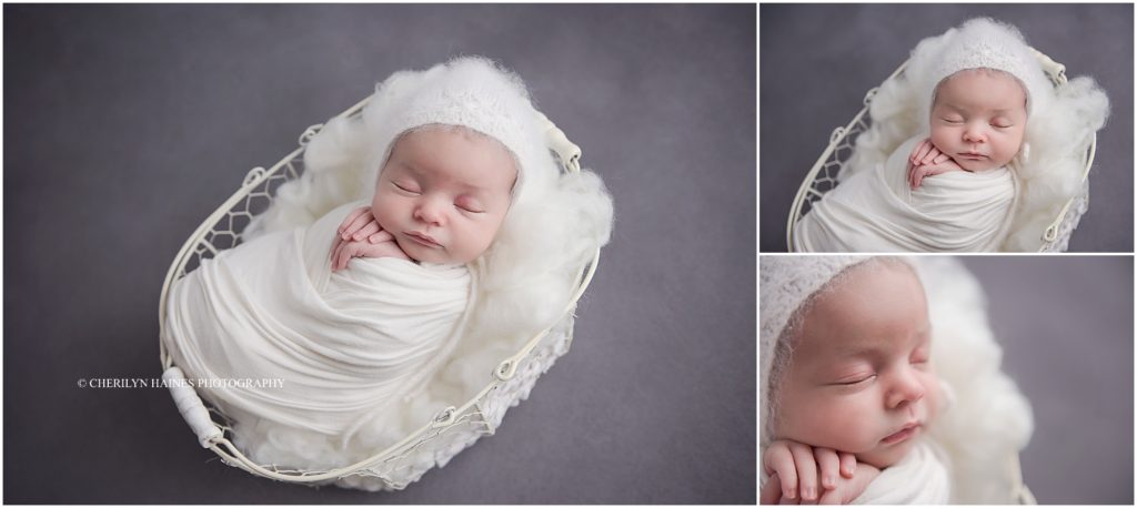 newborn baby girl swaddled in white with white knit bonnet