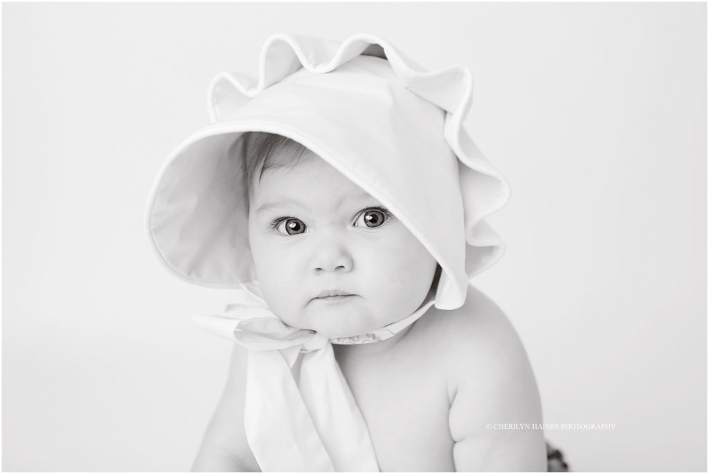 black and white portrait of baby girl wearing a bonnet photographed by cherilyn haines photography