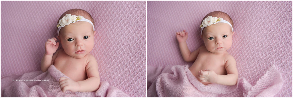 awake newborn posed on pink blanket