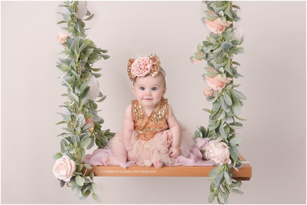 6 month portraits; baby girl sitting on floral swing