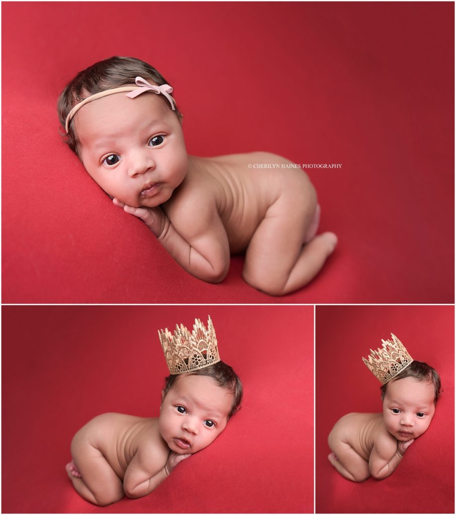 awake newborn baby girl posed on red blanket with tiny gold tiara